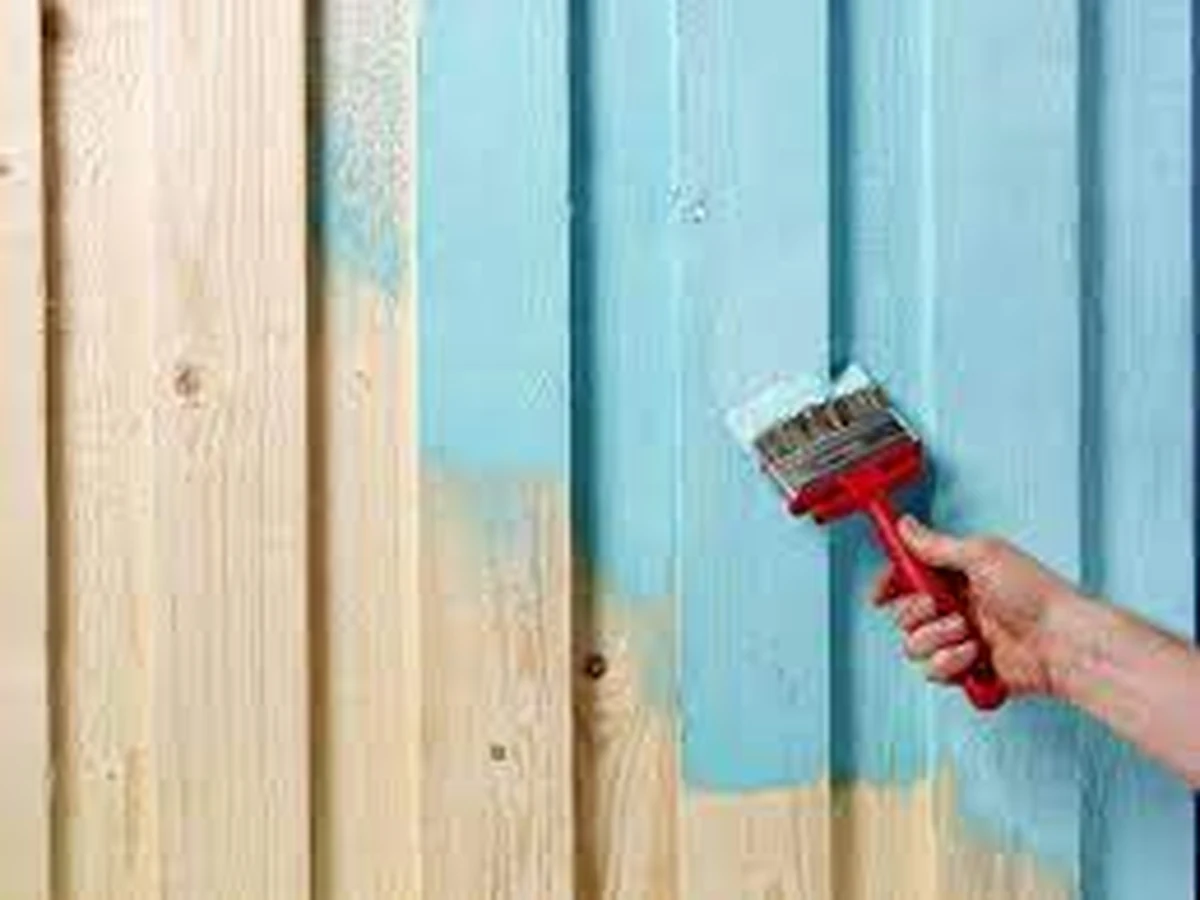 Painter applying paint by brush to timber surface in Chesterfield, Chesterfield Decorators
