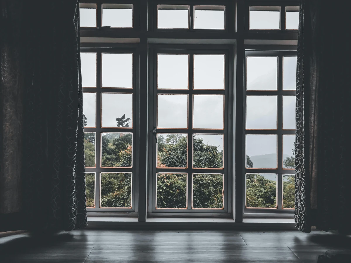 Window frame painting in Chesterfield by Chesterfield Decorators, brown timber sash window close-up